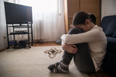 girl sitting on the floor with her head on her knees