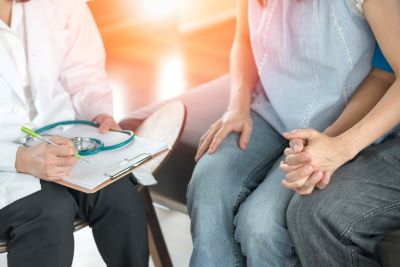 two people holding hands talking to a health professional