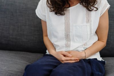 woman sitting down holding her hands together on her lap