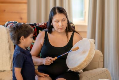 Indigenous woman drumming with child