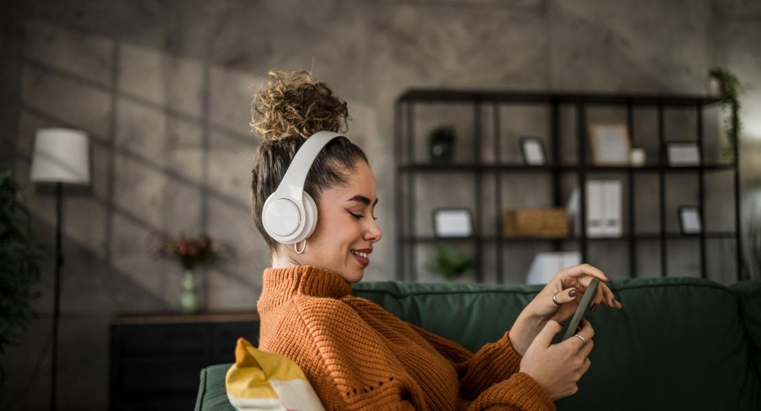 woman wearing headphones looking at her phone