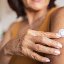 woman pointing to a hormone replacement therapy patch she has on her arm