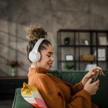 woman wearing headphones looking at her phone